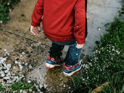 kid jumping in puddle